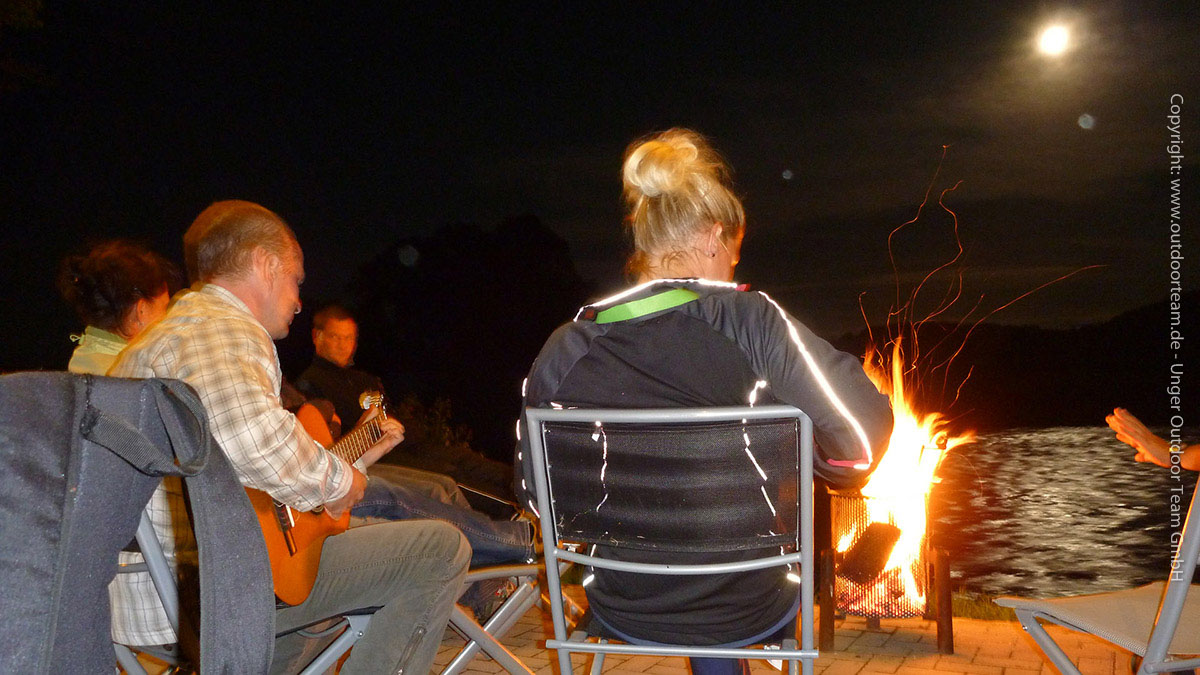 nächtliche Campromantik am Lagerfeuer, dazu Gitarrenklänge, Vollmond und das Plätschern vom Fluss ...
