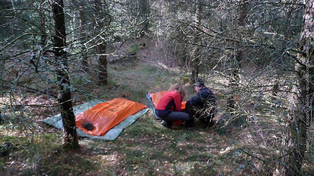 Notlagerbau - die orange Folie ist ein so genannter Survival-Emergency-Bag, eine Art wasserdichter Überschlafsack zum Draussenübernachten.