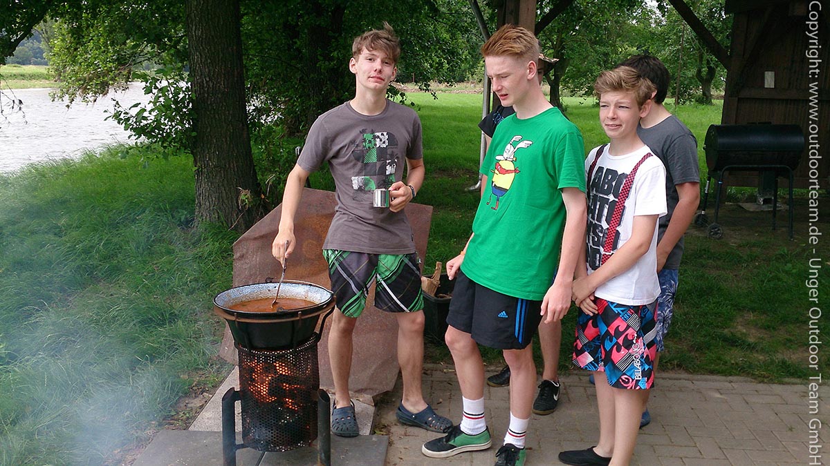 Über dem Feuerkorb wird unter Mithilfe vieler junger Köche das Mittagessen (hier: Gulaschsuppe) zubereitet.